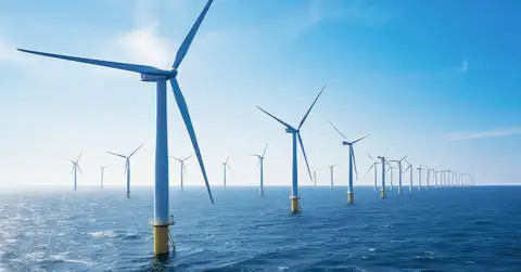 Offshore wind turbines extending across a blue sea